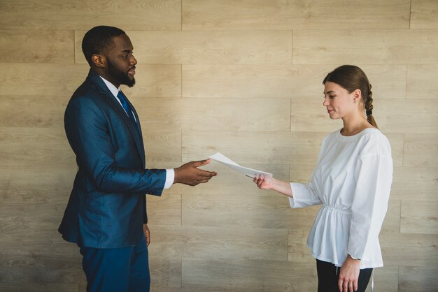 Woman handing paper to businessman