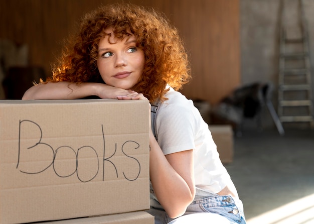 Woman handling belongings in cardboard boxes for moving in new house