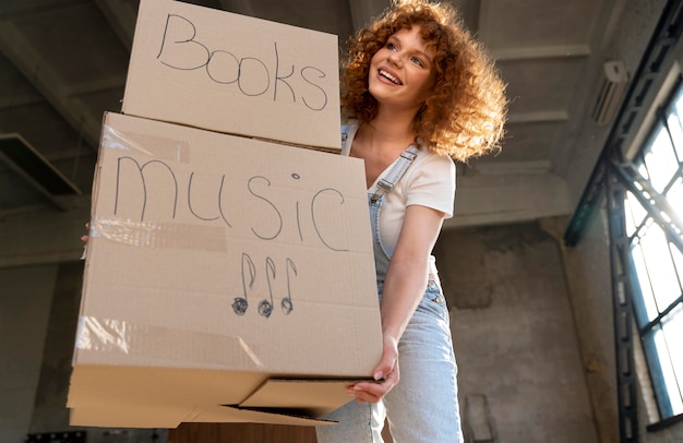 Woman handling belongings in cardboard boxes for moving in new house