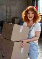 Бесплатное фото Женщина обрабатывает вещи в картонных коробках для переезда в новый дом