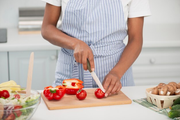 Руки женщины режут вкусные помидоры