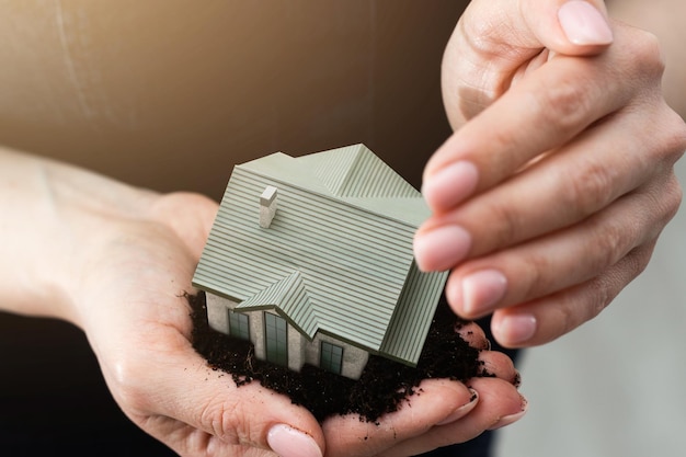 Woman hands holding paper house, model