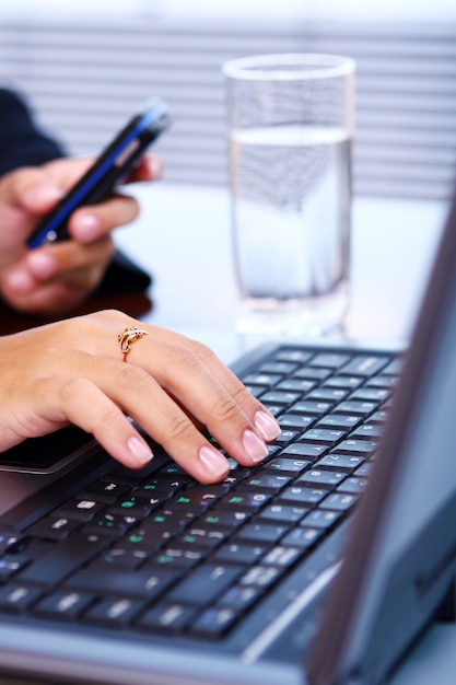 女性はノートパソコンのキーボードに手します。