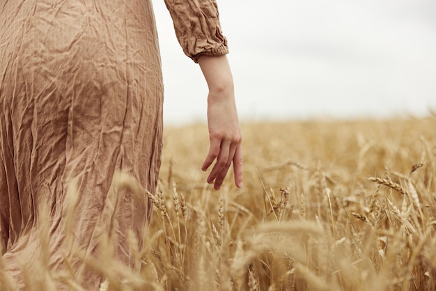初夏の収穫で小麦の穂が熟すのを心配している農家に女性が手渡す