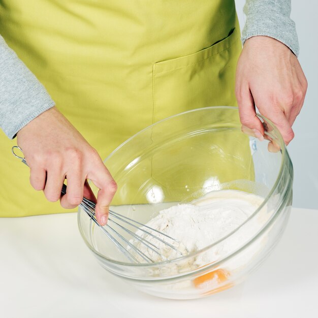 Женщина руки взбивая тесто на кухне