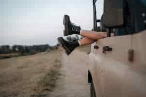 Free photo woman hanging her feet over car while traveling