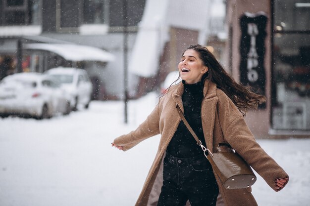Женщина счастлива в пальто зимой снаружи