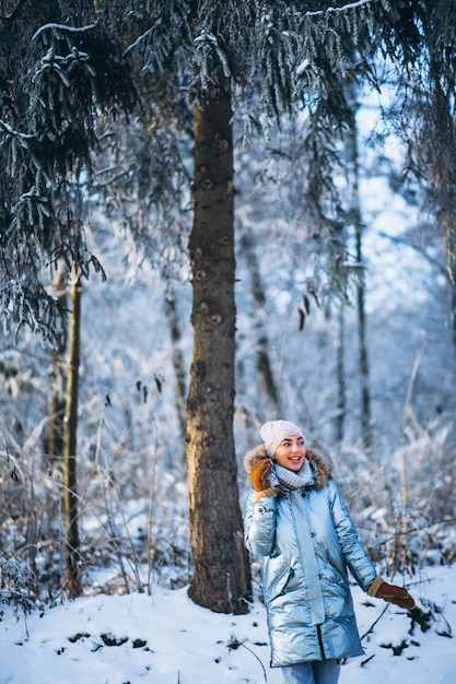 Счастливая женщина гуляет в зимнем парке