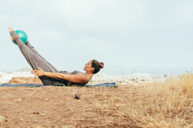 Woman during hard yoga session outdoors