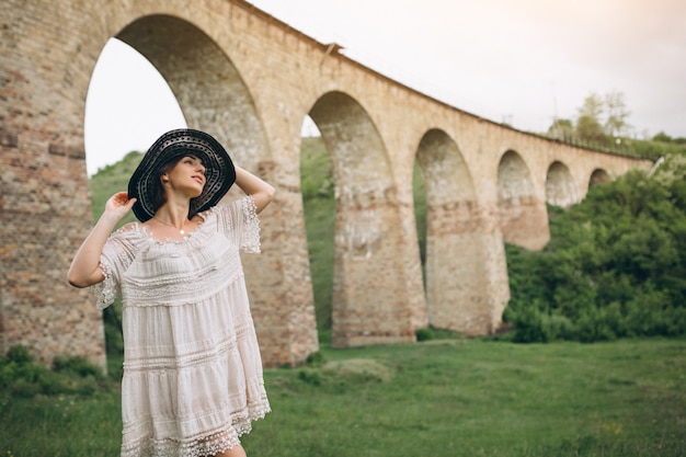 Женщина в шляпе по железной дороге мост