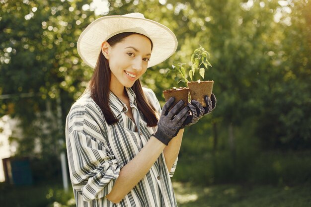 植木鉢を保持している帽子の女