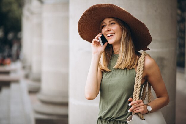 전화 통화하는 휴가에 모자에있는 여자