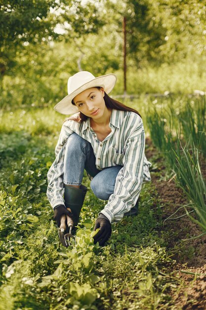 Woman in a hat working in a garden