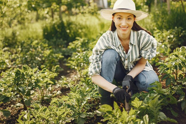 Woman in a hat working in a garden