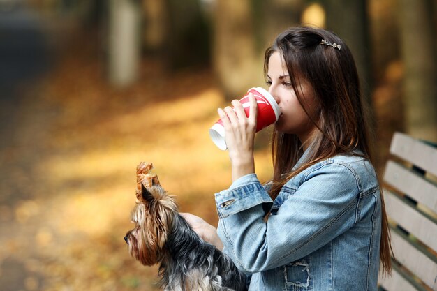Woman have lunch while strolling with her dog