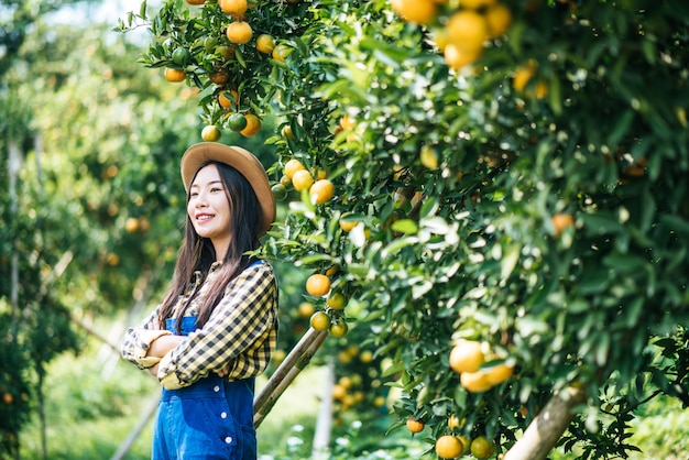 オレンジ色の農園を植える女性