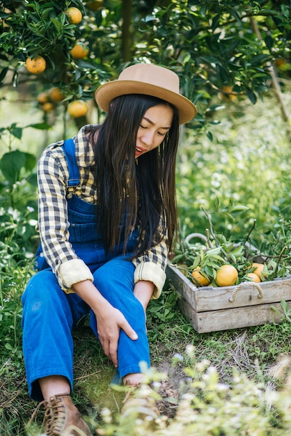 オレンジ色の農園を植える女性