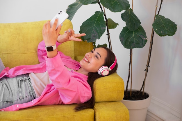無料写真 自宅のソファに座りながらスマートフォンでビデオ通話をする女性