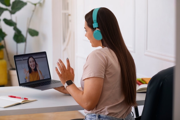 무료 사진 집에서 노트북 기기를 사용하여 화상 통화를 하는 여성