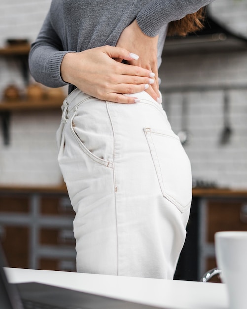 Free photo woman having a backache while working from home