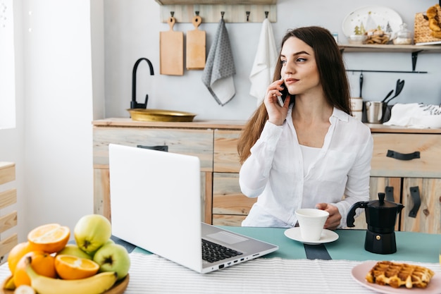 Woman having breakfast at the kitchen