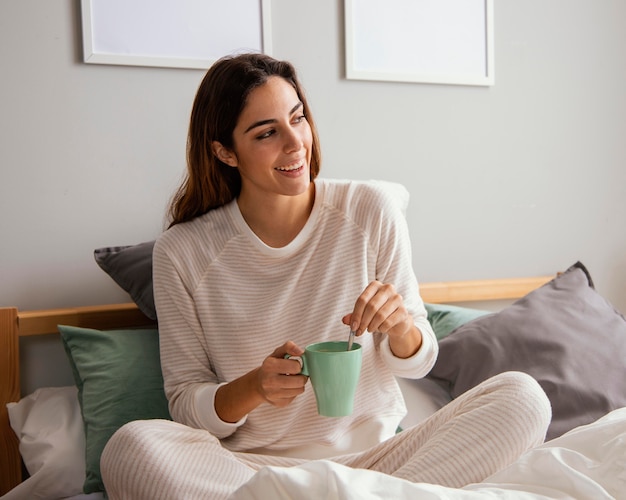 Donna che mangia caffè a letto