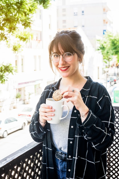 Free photo woman having cookie with cup of tea