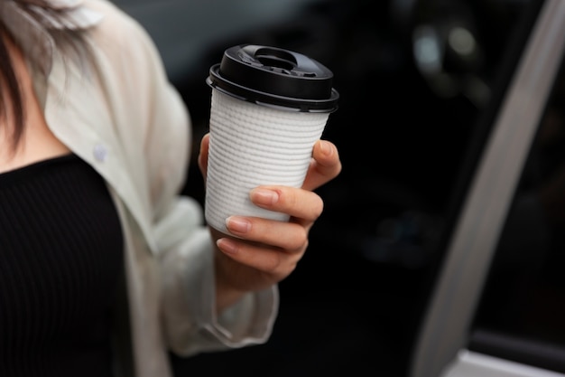 電気自動車でコーヒーを飲んでいる女性