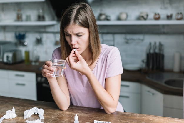 Foto gratuita donna che ha febbre che prende medicina a casa