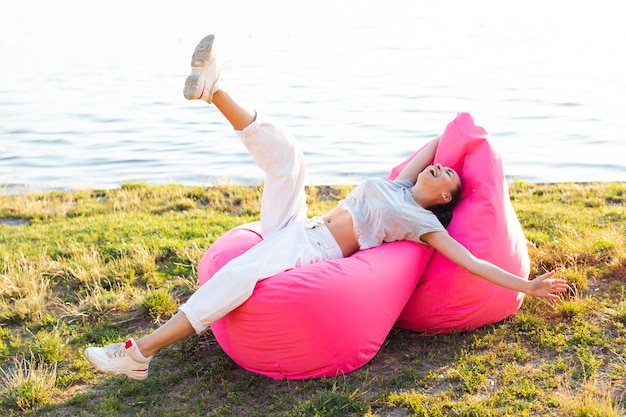 Free photo woman having a fun time on pink beanbags