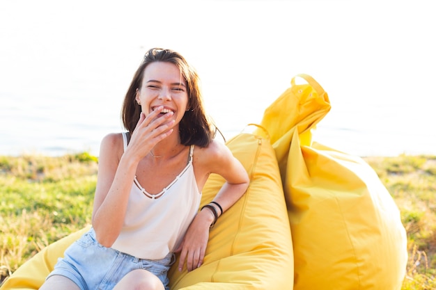 Woman having a fun time on yellow beanbags 