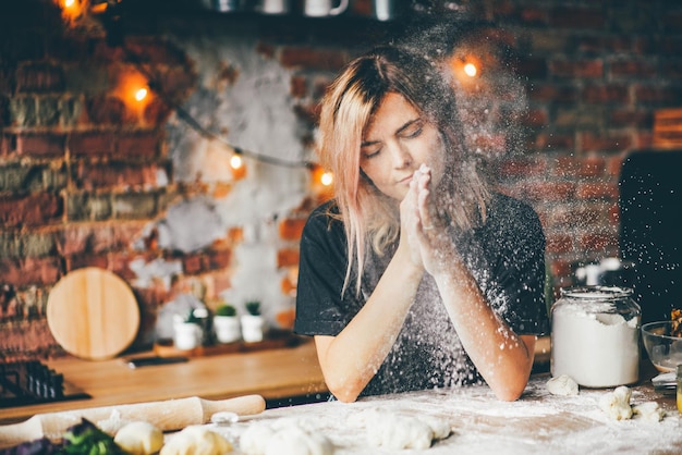 Woman having fun with flour in the kitchen.