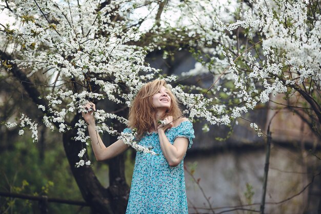 Женщина с удовольствием с цветущих деревьев