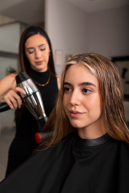 Free photo woman having hair treatment of latino hair salon