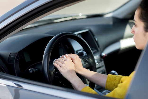 Woman having her hands on steering wheel