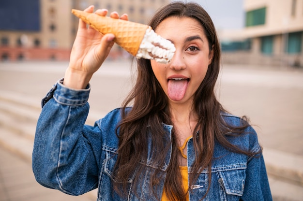 Foto gratuita donna che mangia gelato all'aperto