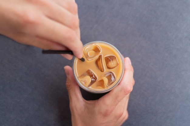 外でアイスコーヒーを飲む女性