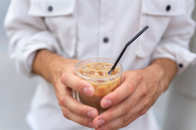 外でアイスコーヒーを飲む女性