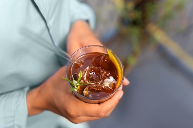 Donna che fa una pausa caffè ghiacciata fuori