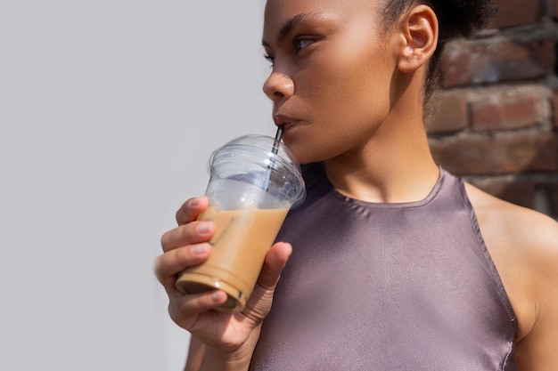 Donna che fa una pausa caffè ghiacciata fuori