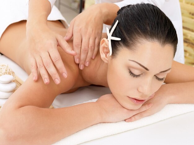 Женщина, имеющая массаж тела в спа-салоне. Концепция лечения красоты.