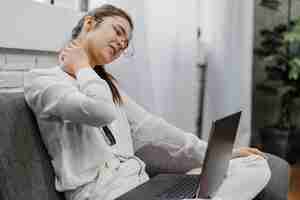 Free photo woman having a neckache as she works at home