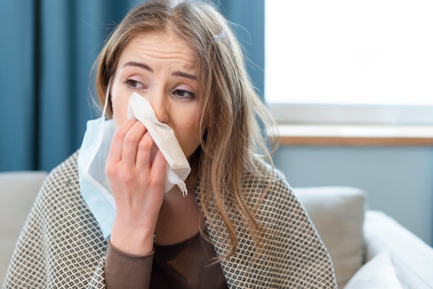 Woman having a runny nose indoors