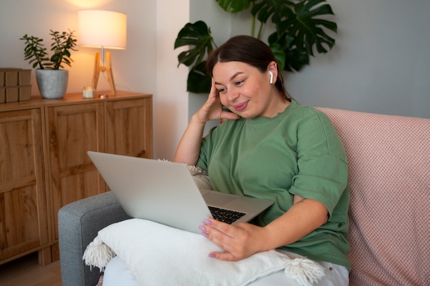 Free photo woman having a video call at home on a laptop device