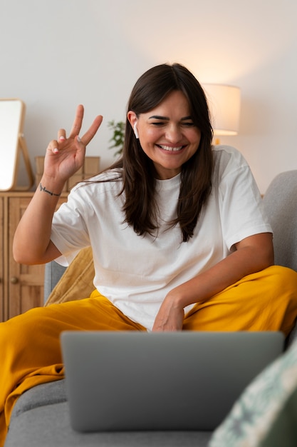 Free photo woman having a video call at home on a laptop device