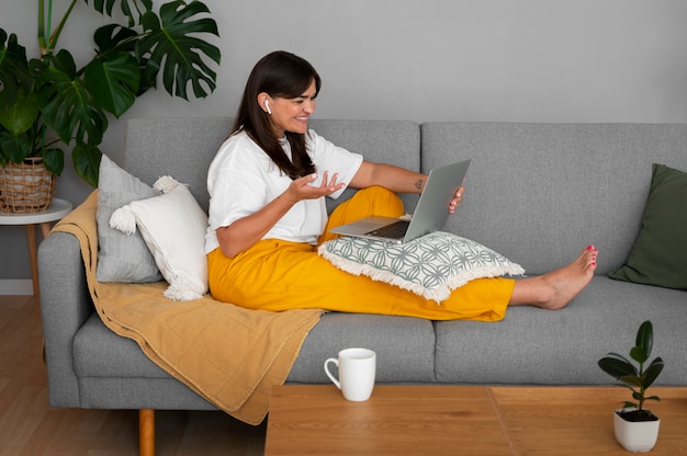 Free photo woman having a video call at home on a laptop device