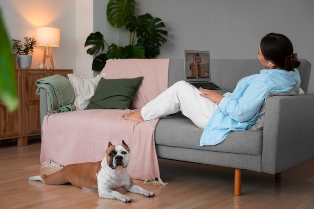 Free photo woman having a video call at home on a laptop device