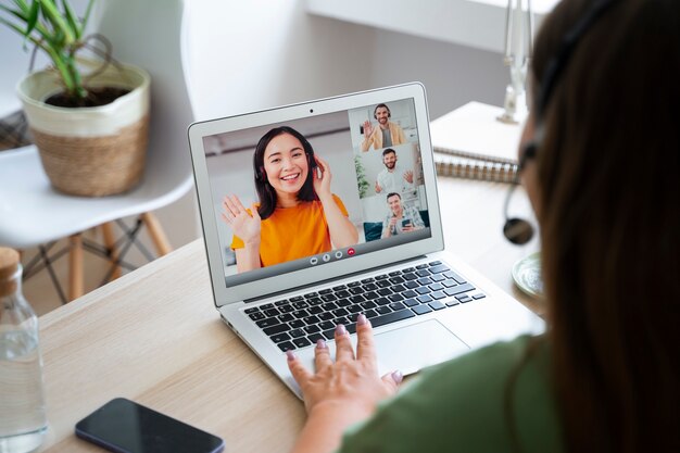 Женщина делает видеозвонок дома на ноутбуке с наушниками