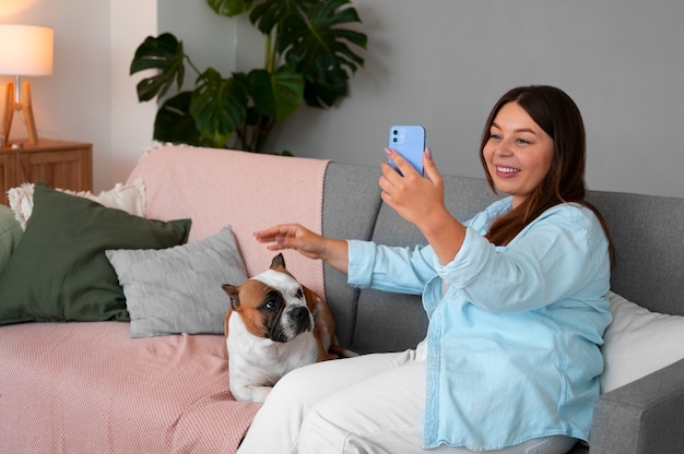 スマートフォンで自宅でビデオコールをしている女性