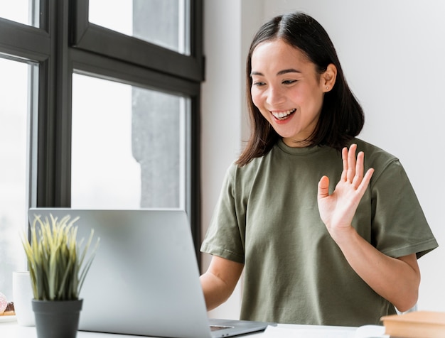 Free photo woman having video call on laptop